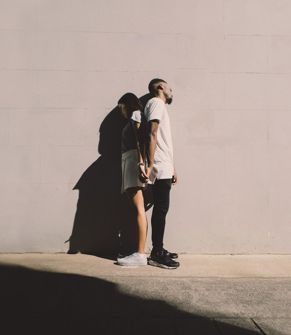 A couple holding hands and facing away from each other