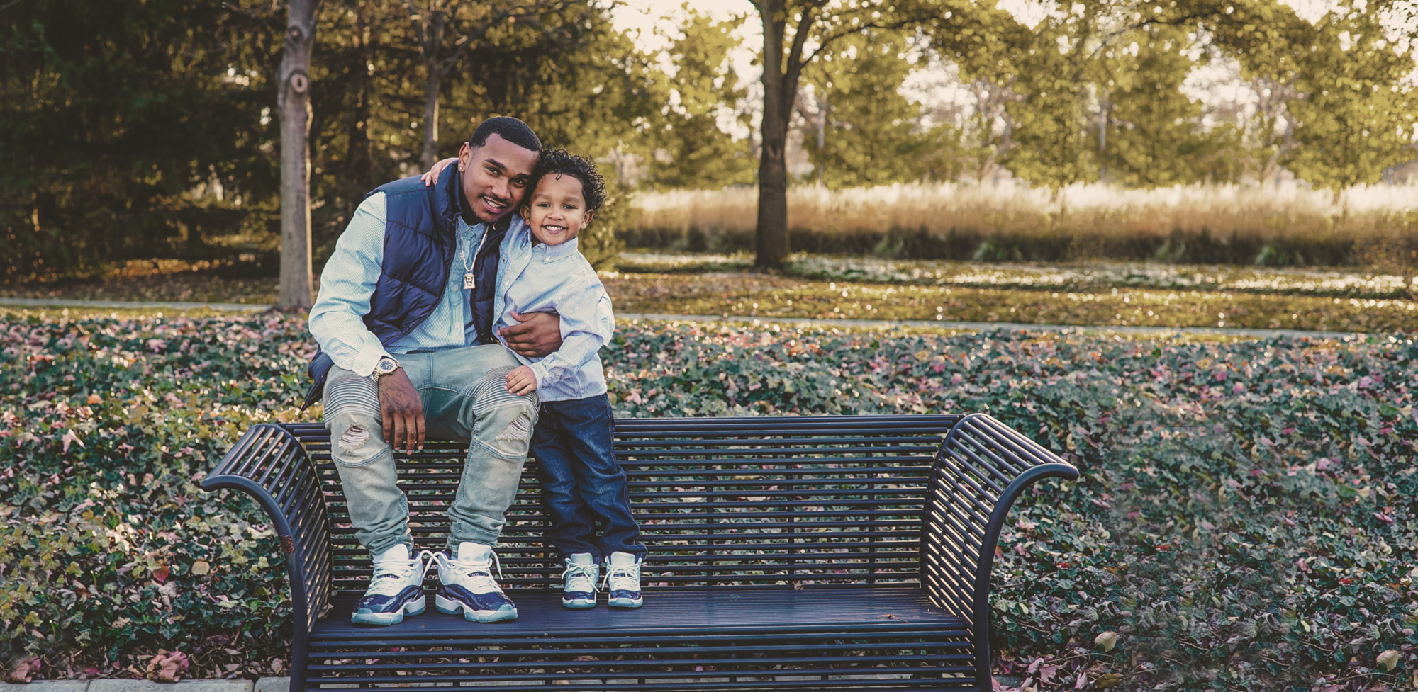 Father and son sitting on park bench