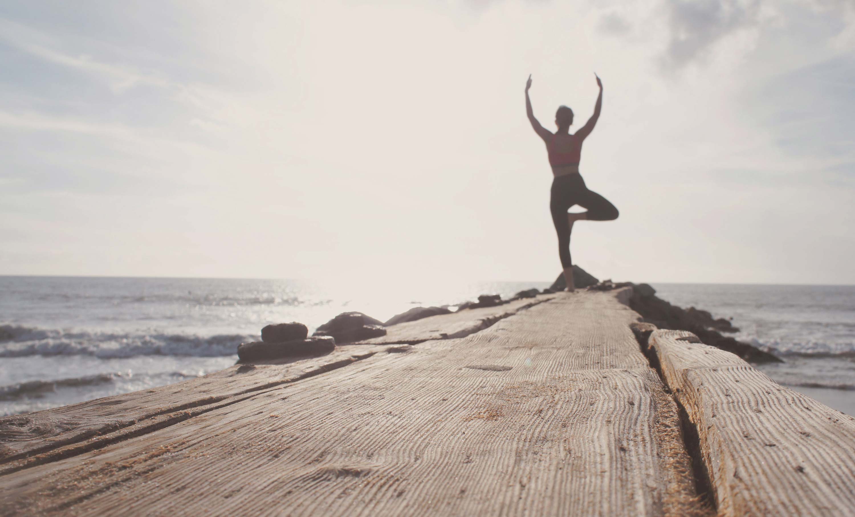 Woman doing yoga on a pier