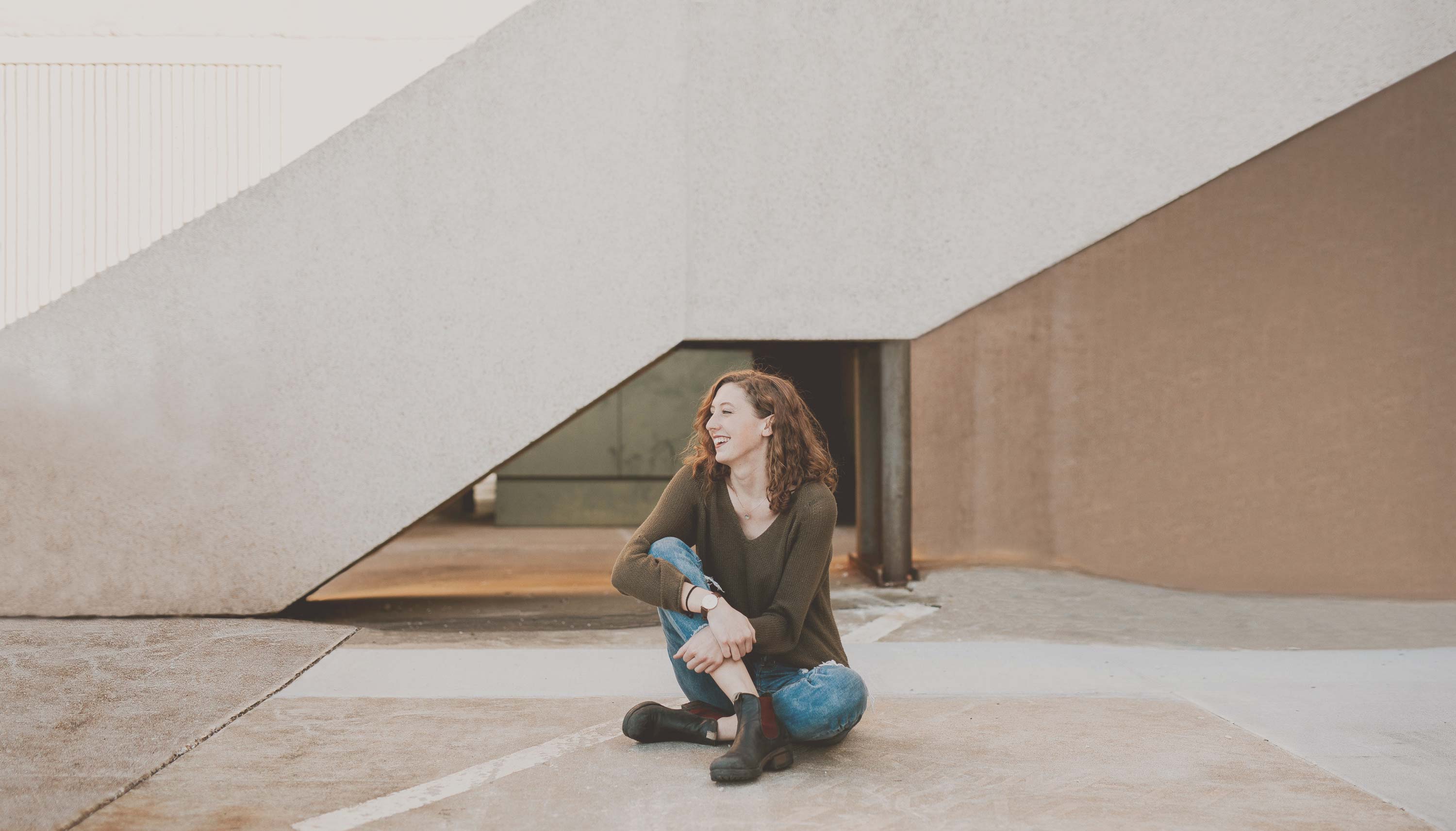 Smiling woman sitting on the sidewalk